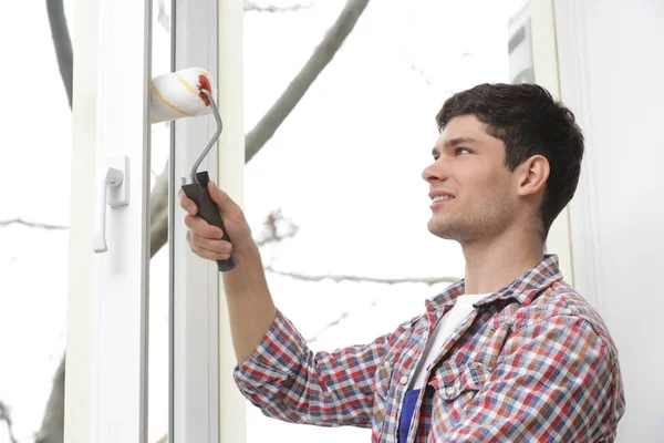 Hombre joven pintando ventana — Foto de Stock