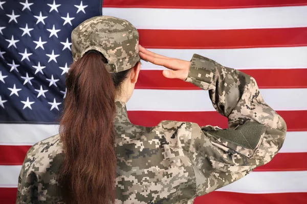 Saluting female soldier with USA flag on background — Stock Photo, Image