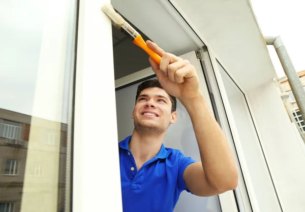 Homem pintando janela em casa — Fotografia de Stock