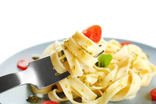 Gaffel med velsmakende pasta og tallerken på bakgrunn – stockfoto