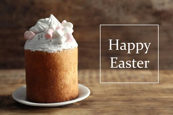 Tasty traditional cake and text HAPPY EASTER on wooden background — Stock Photo, Image