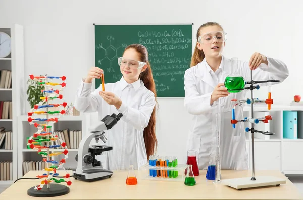 Ragazze della scuola sul posto di lavoro in classe di chimica — Foto Stock