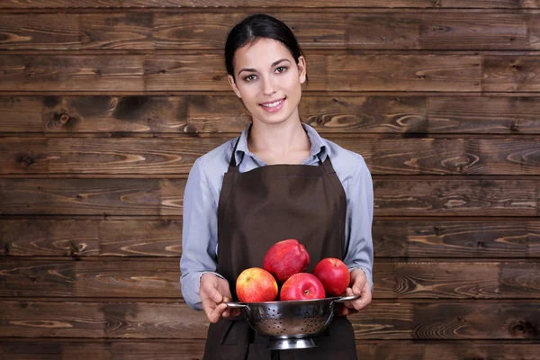 Mujer joven sosteniendo manzanas — Foto de Stock