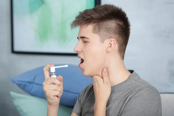 Young man using throat spray — Stock Photo, Image