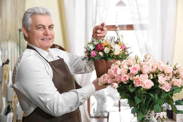 Florist holding basket with flowers — Stock Photo, Image
