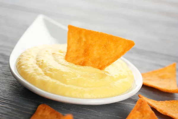 Mergulhando batatas fritas em tigela com molho de queijo — Fotografia de Stock