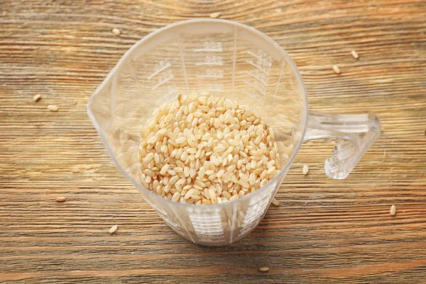 Taza de medir con arroz integral —  Fotos de Stock