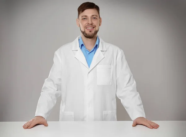 Junge Apothekerin steht am Tisch — Stockfoto