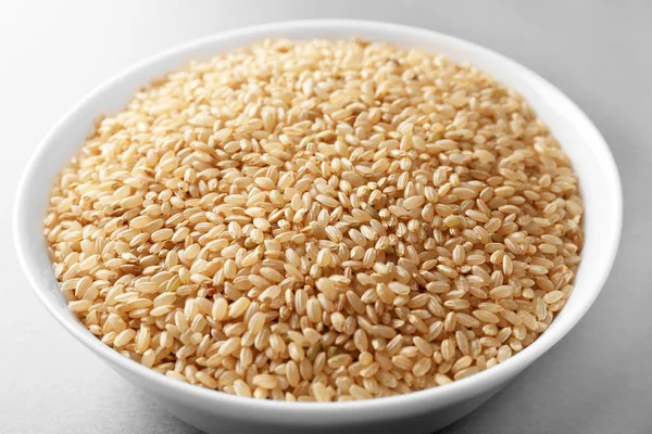 Tigela com arroz cru na mesa — Fotografia de Stock
