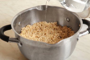 Kahverengi pirinç, closeup ile tava içine su dökme