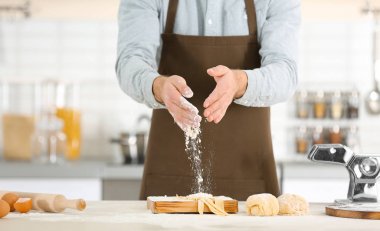 Adam makarna mutfak masasının üzerine hazırlanıyor