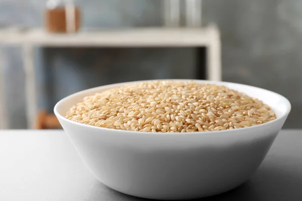 Miska z surowym ryżem na stole — Zdjęcie stockowe