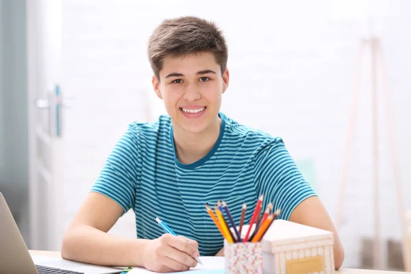 Teenager taking notes at home — Stock Photo, Image
