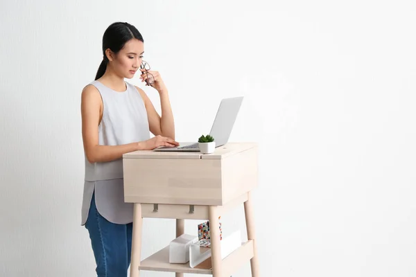 Aziatische vrouw te typen op laptop — Stockfoto