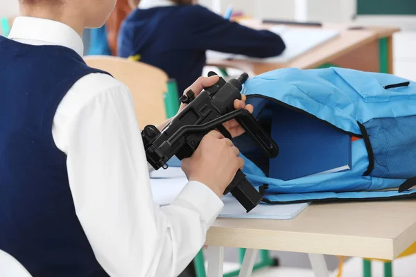 Schoolboy holding machine gun — Stock Photo, Image