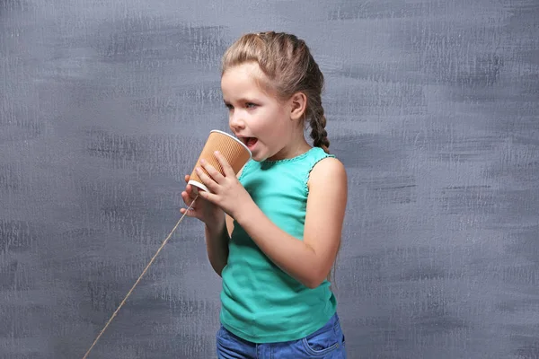Meisje met plastic beker als telefoon — Stockfoto