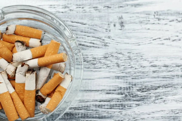 Glass ashtray with cigarette butts — Stock Photo, Image