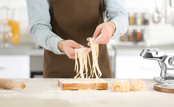 Hombre preparando pasta en la mesa de la cocina —  Fotos de Stock