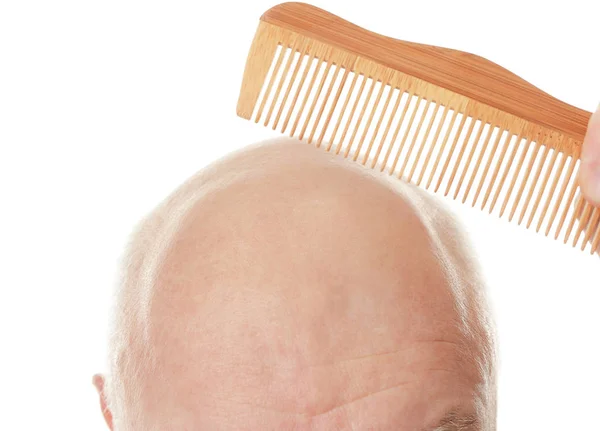 Homem sênior careca com pente no fundo branco, close-up — Fotografia de Stock