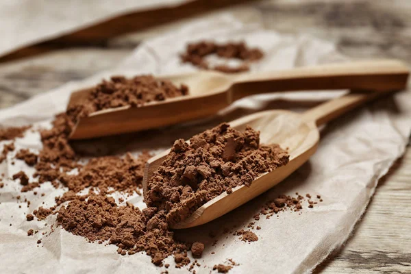 Cucharas de madera con cacao en polvo —  Fotos de Stock