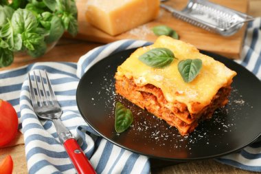 Lezzetli lazanya ve çizgili peçete, closeup ile siyah plaka