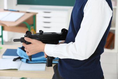 okul çocuğu holding makineli tüfek