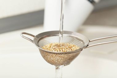 Elek içinde Quinoa tohumları yıkama