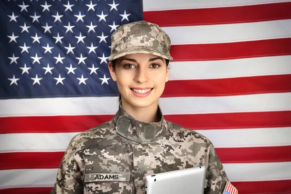 Soldat féminin avec tablette sur fond drapeau des États-Unis — Photo