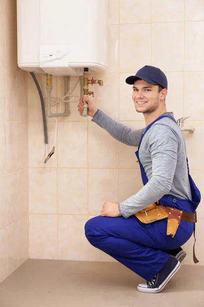 Encanador reparação caldeira no banheiro — Fotografia de Stock