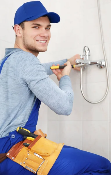 Handsome plumber fixing faucet — Stock Photo, Image