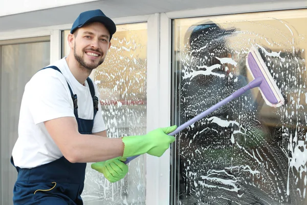 Genç adam yıkama pencere — Stok fotoğraf
