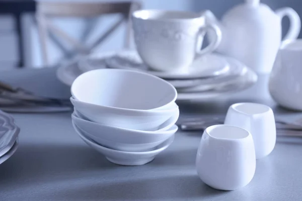 White dishes on grey table — Stock Photo, Image