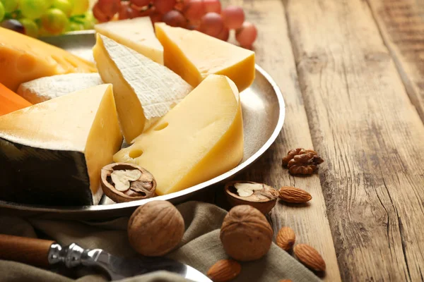 Tablett mit köstlichem Käse, Trauben und Nüssen — Stockfoto