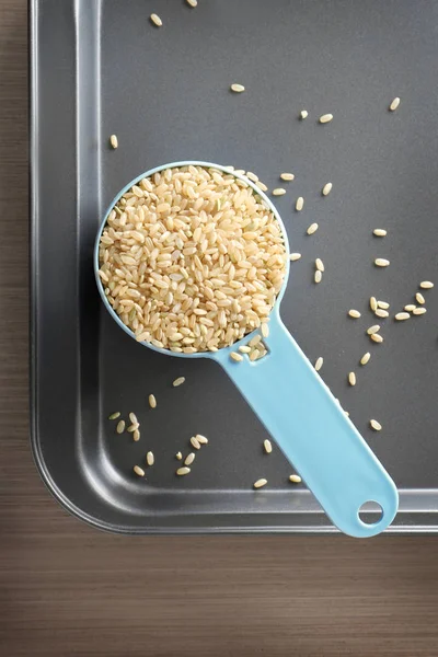 Measure scoop with brown rice — Stock Photo, Image
