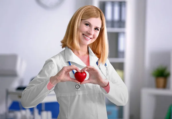 Женщина-врач держит сердце — стоковое фото