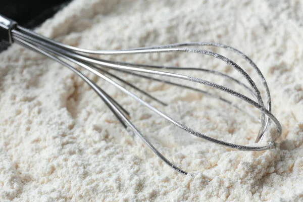 Whisk on heap of flour — Stock Photo, Image