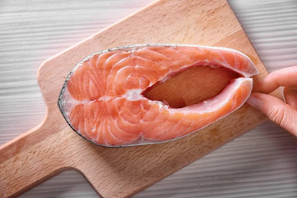 Рука положить свежий стейк лосося — стоковое фото