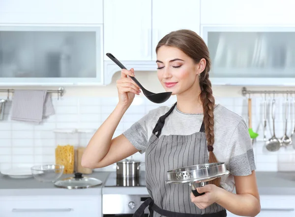 Cooking concept. Young woman tasting food — Stock Photo, Image
