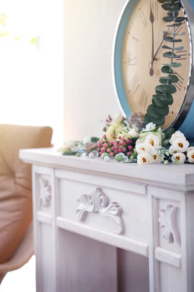 Fresh flowers and vintage clock on mantelpiece — Stock Photo, Image