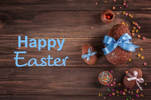 Deliziose prelibatezze e testo BUON PASQUA su sfondo di legno — Foto Stock