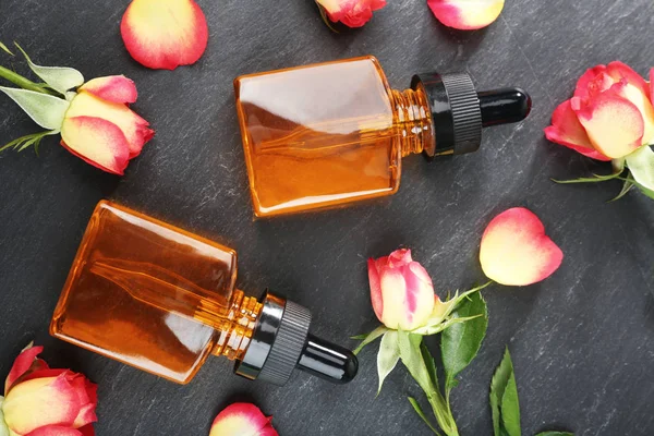 Botellas con aceite de perfume y capullos de rosa — Foto de Stock