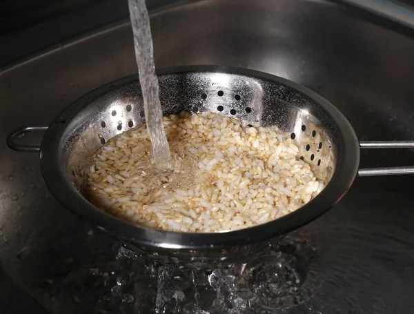 Washing brown rice with water — Stock Photo, Image