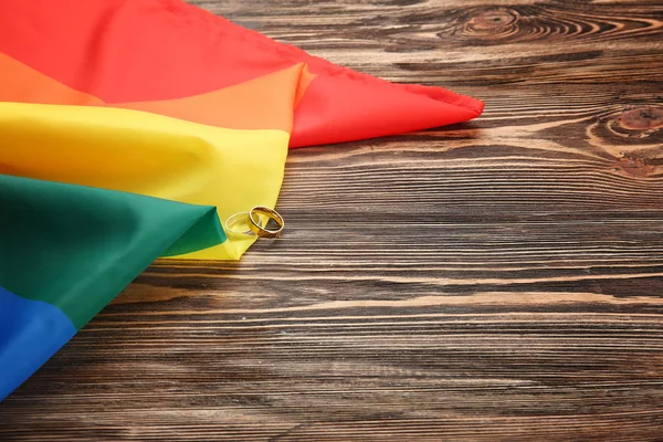 Dois anéis de casamento e bandeira gay arco-íris — Fotografia de Stock