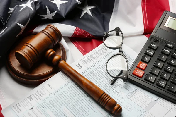 Judge gavel, calculator, eyeglasses and tax forms