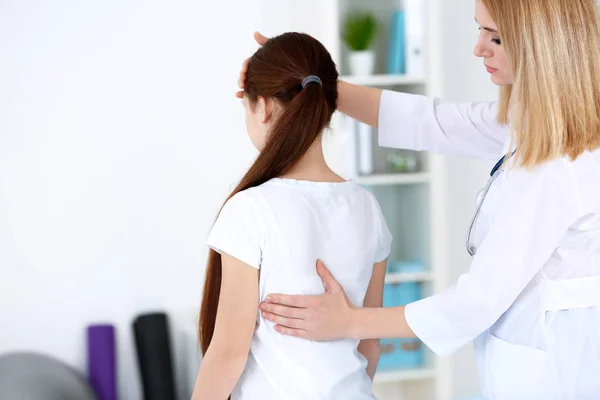 Incorrect posture concept. Physiotherapist examining and correcting girl's back — Stock Photo, Image