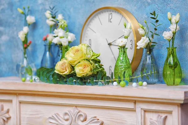 Fleurs fraîches et horloge sur cheminée — Photo
