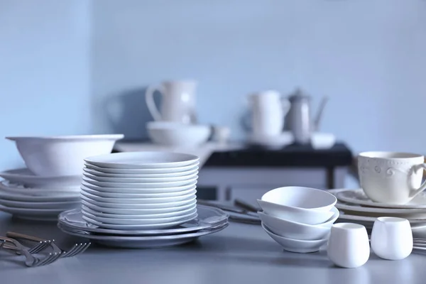 Bílé nádobí na šedý stůl — Stock fotografie