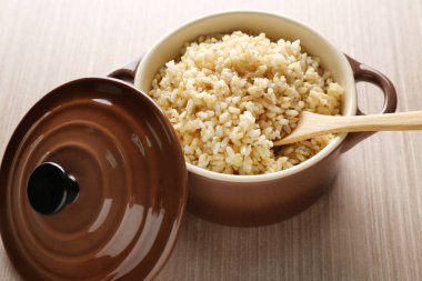 Modern seramik tencere ahşap masa üzerinde haşlanmış kahverengi pirinç dolu