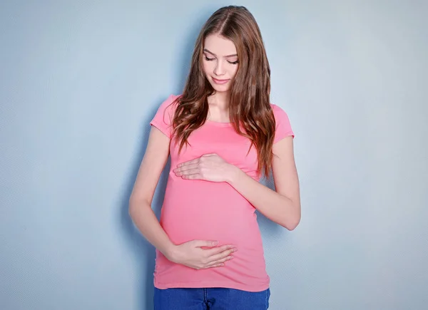 Mooie zwangere vrouw op lichte achtergrond — Stockfoto