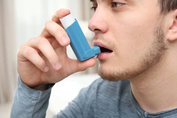 Hombre joven usando inhalador — Foto de Stock